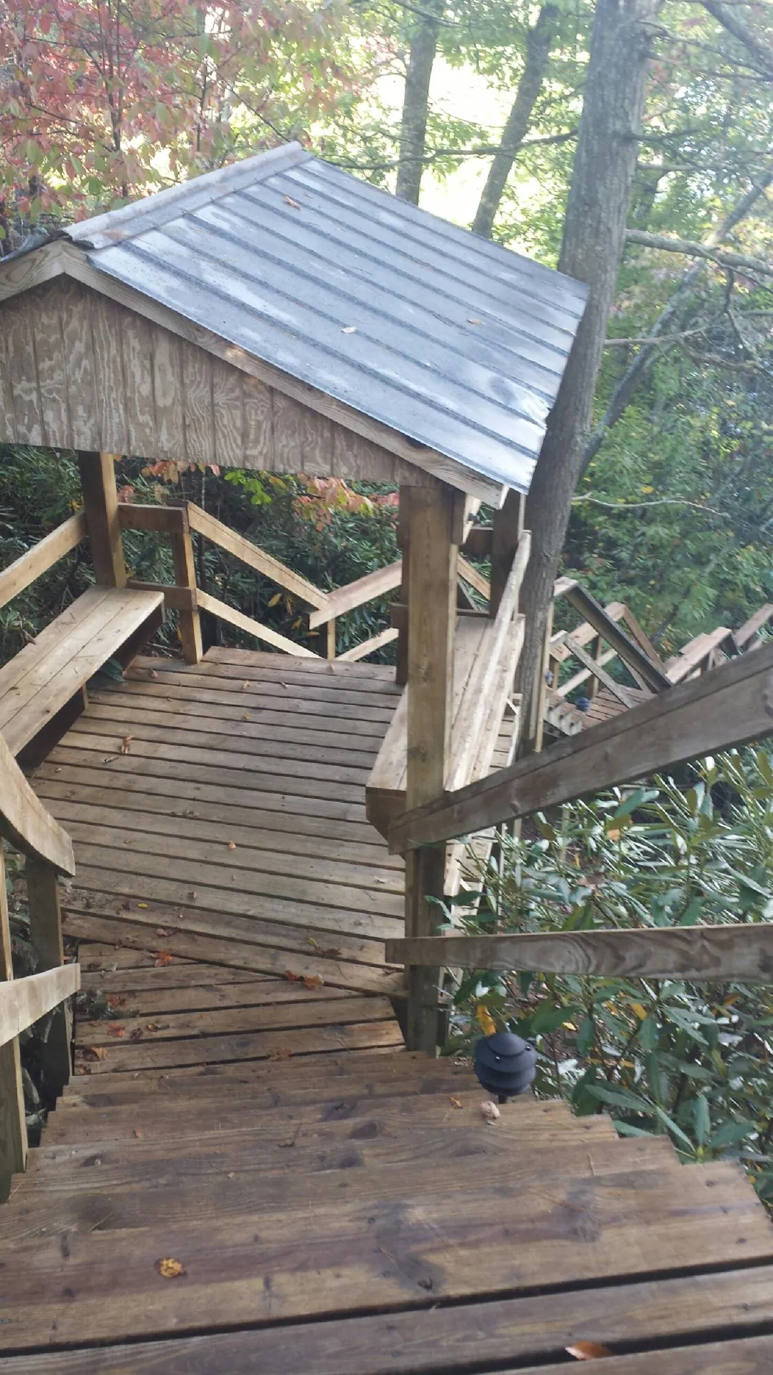 Metal roofed shelter over wooden steps on a wooded walkway — Skylight Repair & Installation work by our crew in Kimberly